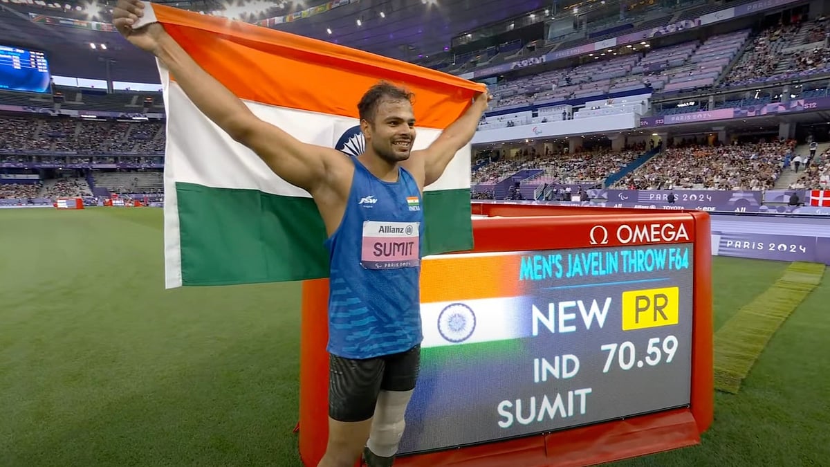 PCI : Sumit Antil poses with the Indian flag after winning gold in the Men's Javelin F64 category.